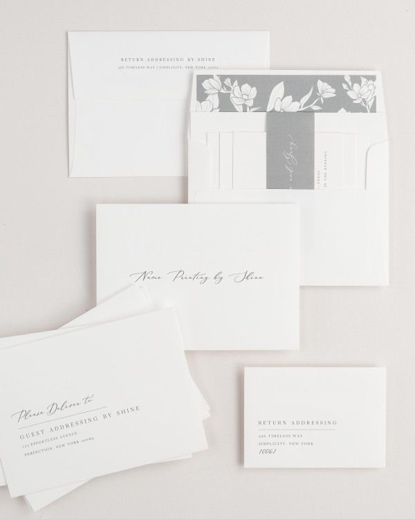 Annalena wedding invitation envelopes with guest addressing, return addressing, and name printing services. Inner envelope features a magnolia liner and slate belly band.