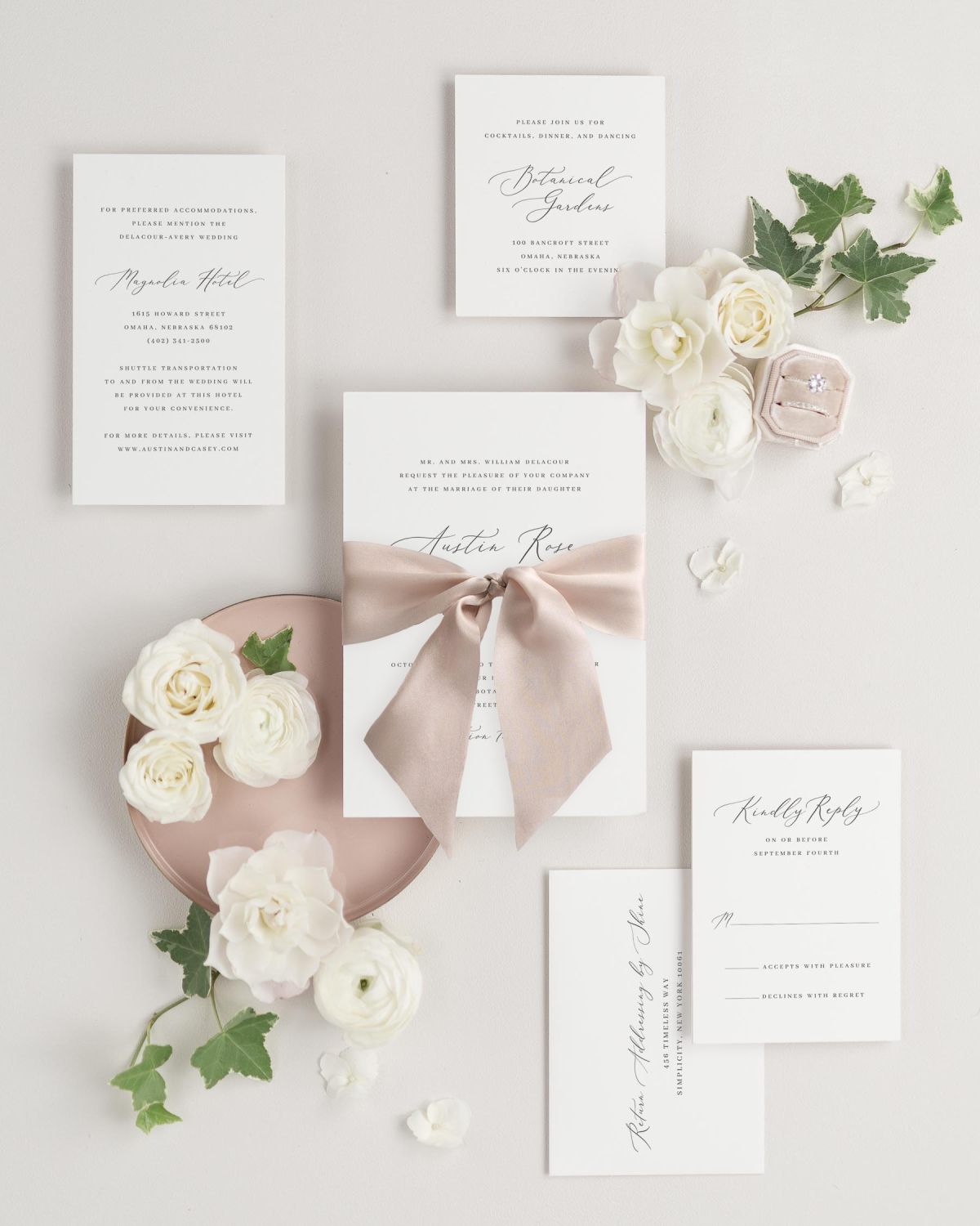 An Austin wedding invitation suite is styled on a neutral background with florals and Antoinette silk ribbon.