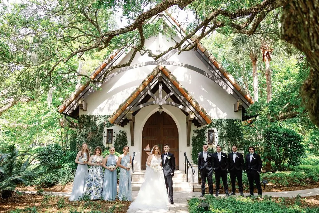 The Bride and Groom and Bridal Party Standing in Front of a Chapel