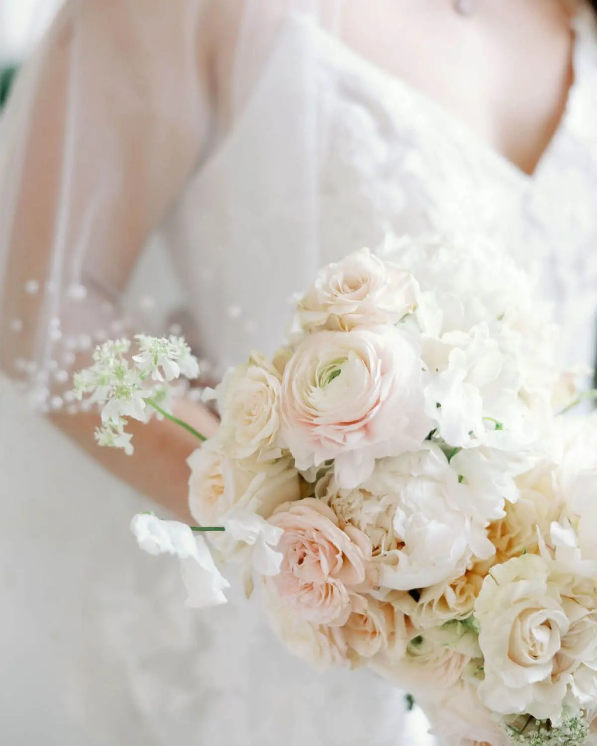 The Bride Holding a Neutral Bridal Bouquet with Subtle Touches of Pink and Yellow