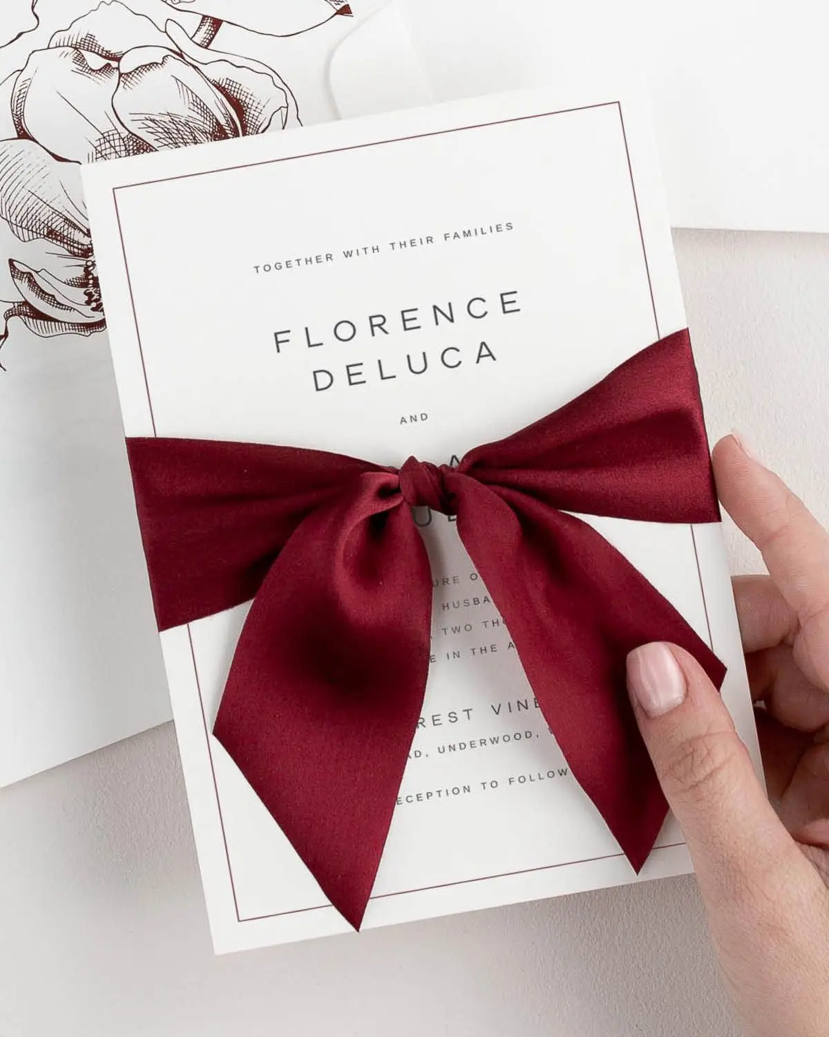 Dark Red Silk Ribbon Tied Around a Florence Wedding Invitation