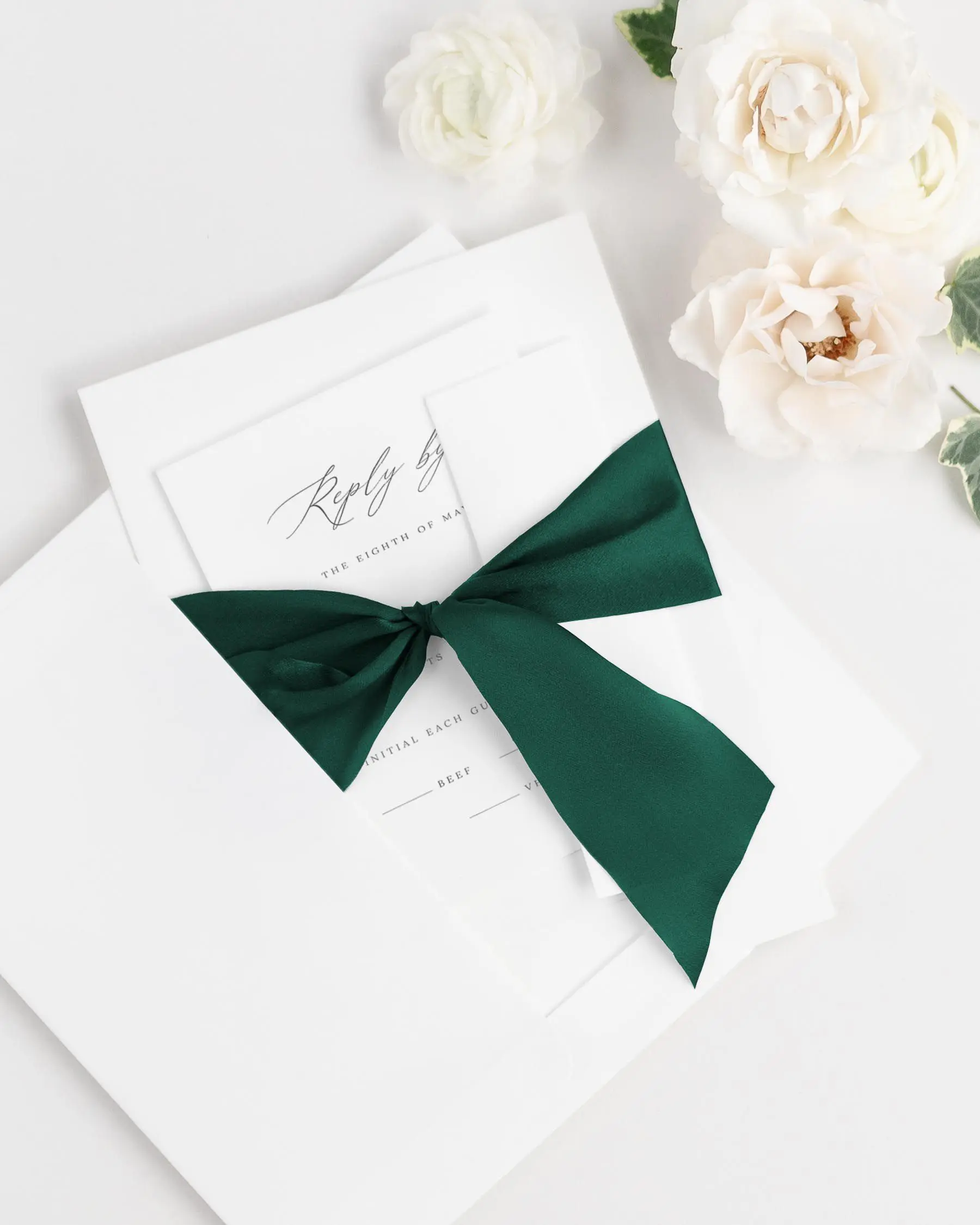 Dark Green Silk Ribbon Tied Around a Noelle Wedding Invitation Suite