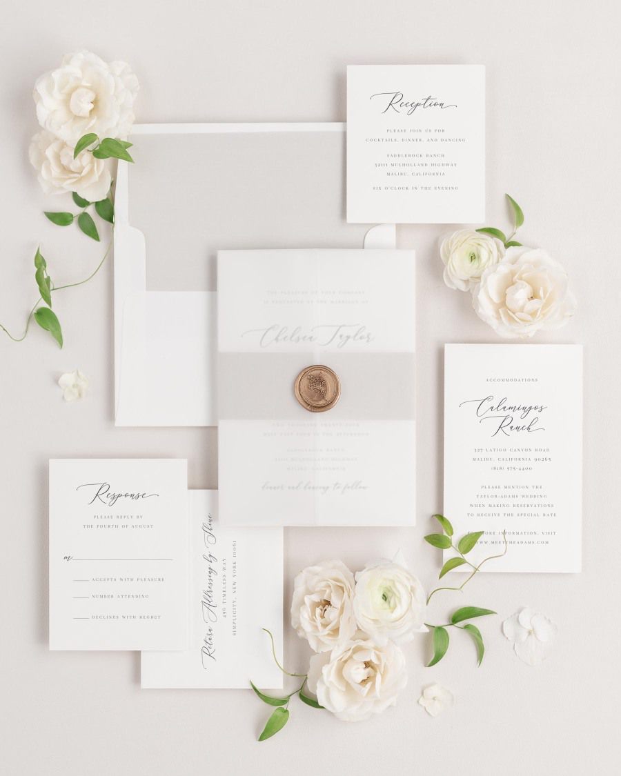 Chelsea wedding invitations flat lay with stone solid liner, stone belly band, translucent vellum jacket, and gold posy wax seal.