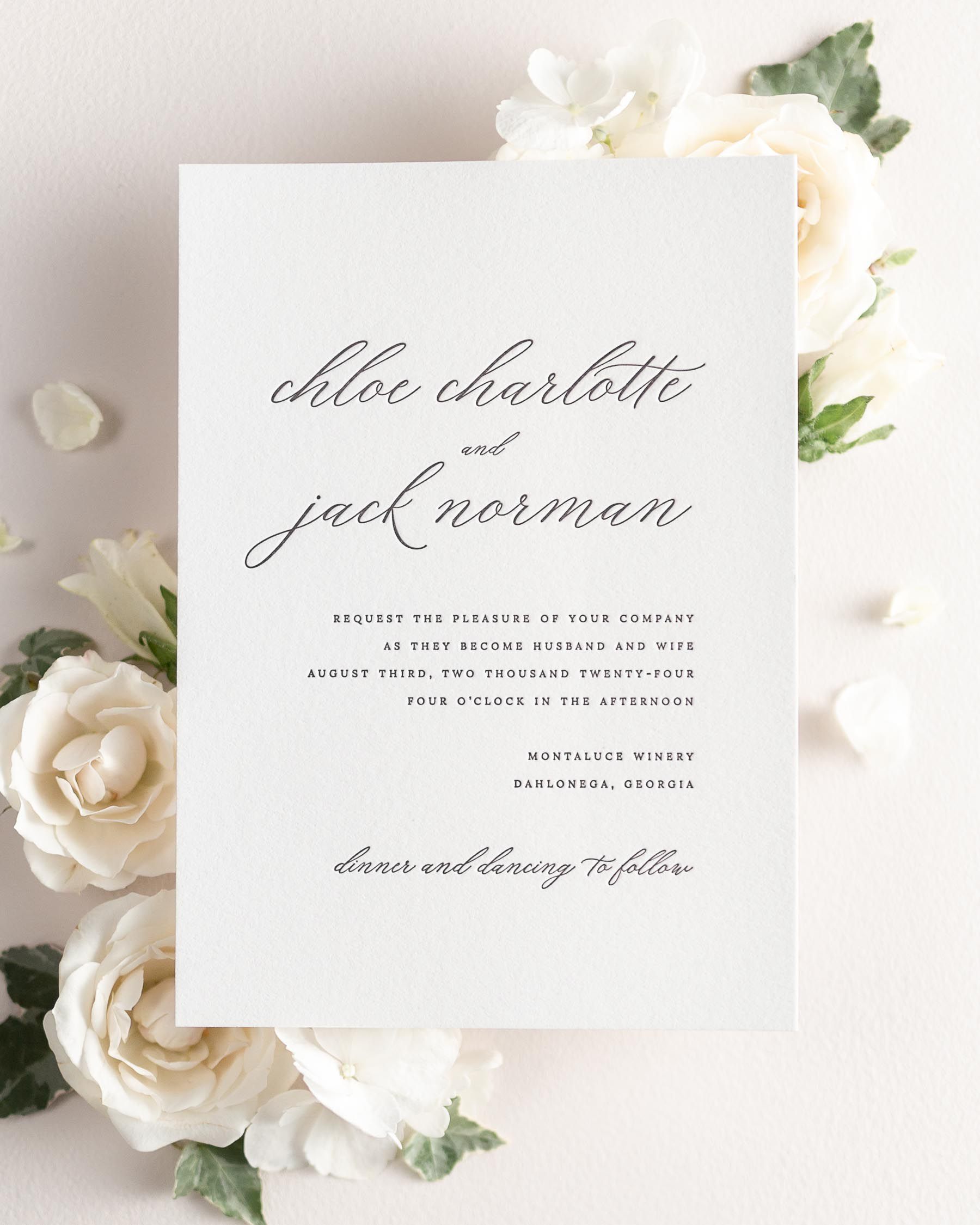 Chloe letterpress wedding invitation styled with pretty florals.