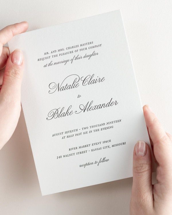 Bride holding her 5x7” Classic Script letterpress wedding invitation.