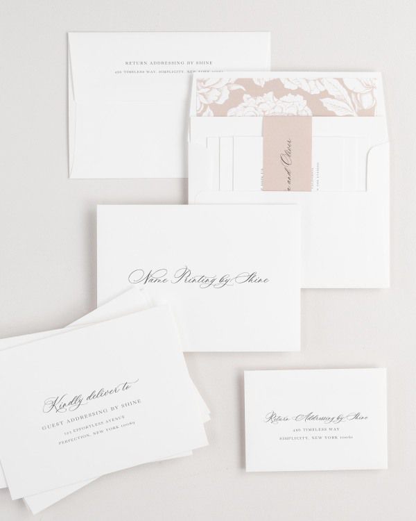 Claudia wedding invitation envelopes with guest addressing, return addressing, and name printing services. Inner envelope features a blooms liner and rosewater belly band.