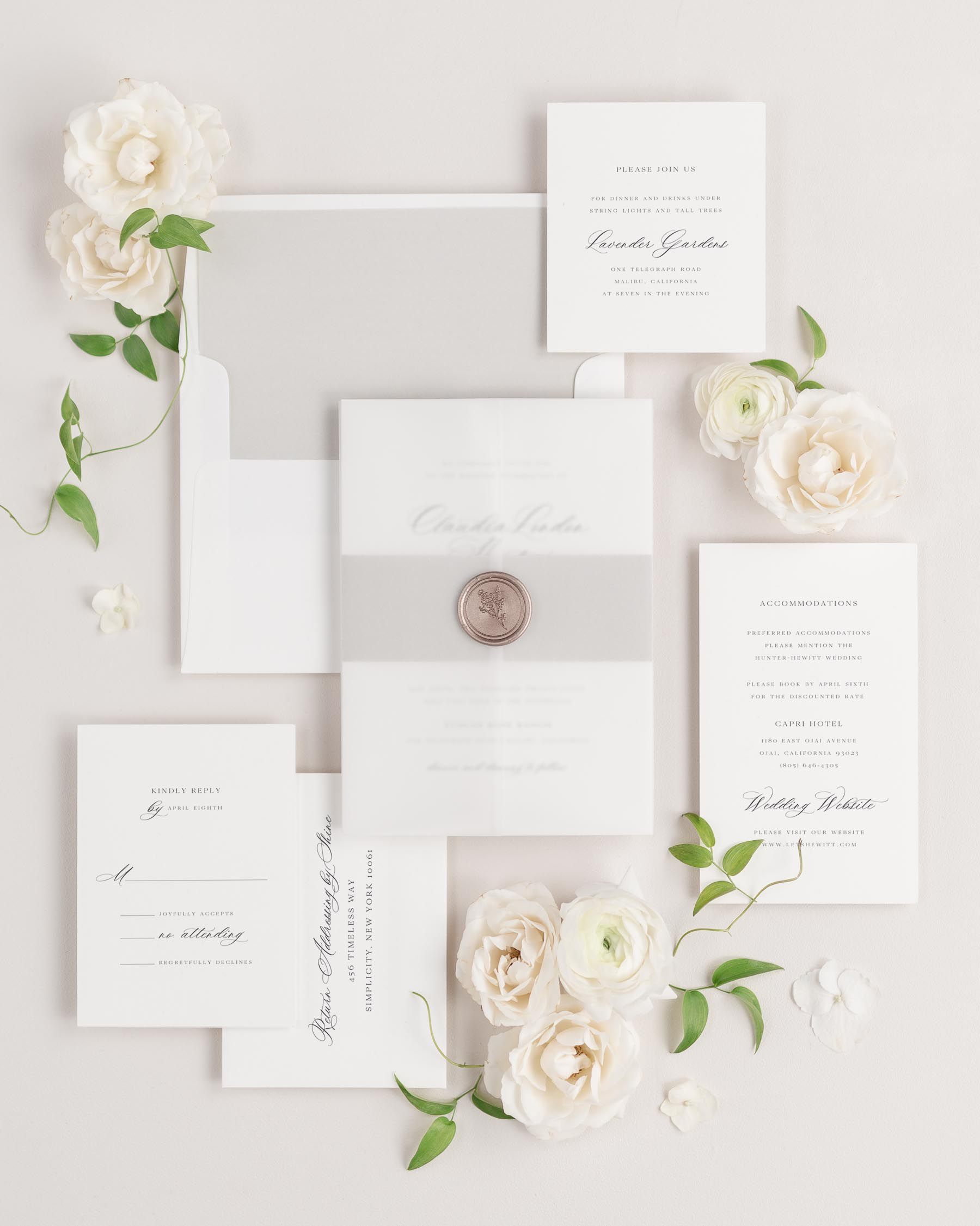 Claudia wedding invitation with a stone belly band, translucent vellum jacket, and bronze posy wax seal.
