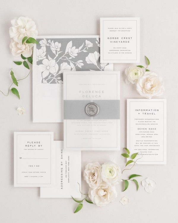 Florence wedding invitations flat lay with slate magnolia liner, slate belly band, translucent vellum jacket, and silver posy wax seal.