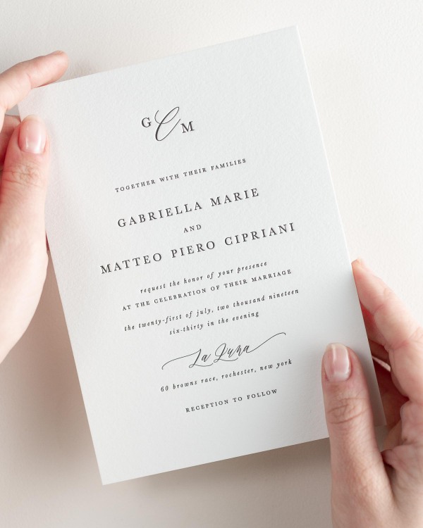 Bride holding her 5x7” Gabriella letterpress wedding invitation.