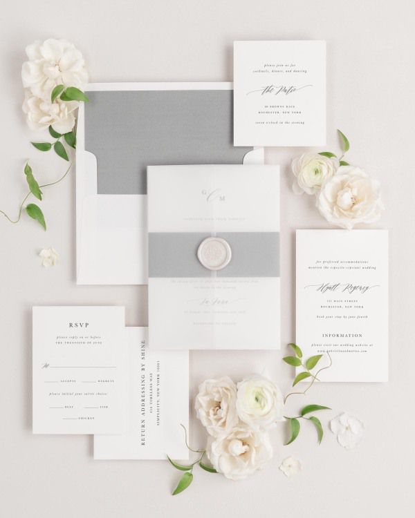 Gabriella wedding invitations flat lay with slate solid liner, slate belly band, translucent vellum jacket, and pearl florette wax seal.