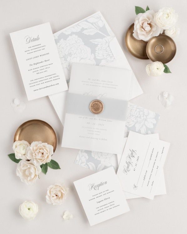 Garden Elegance wedding invitations flat lay with cloud blooms liner, cloud belly band, translucent vellum jacket, and gold florette wax seal.