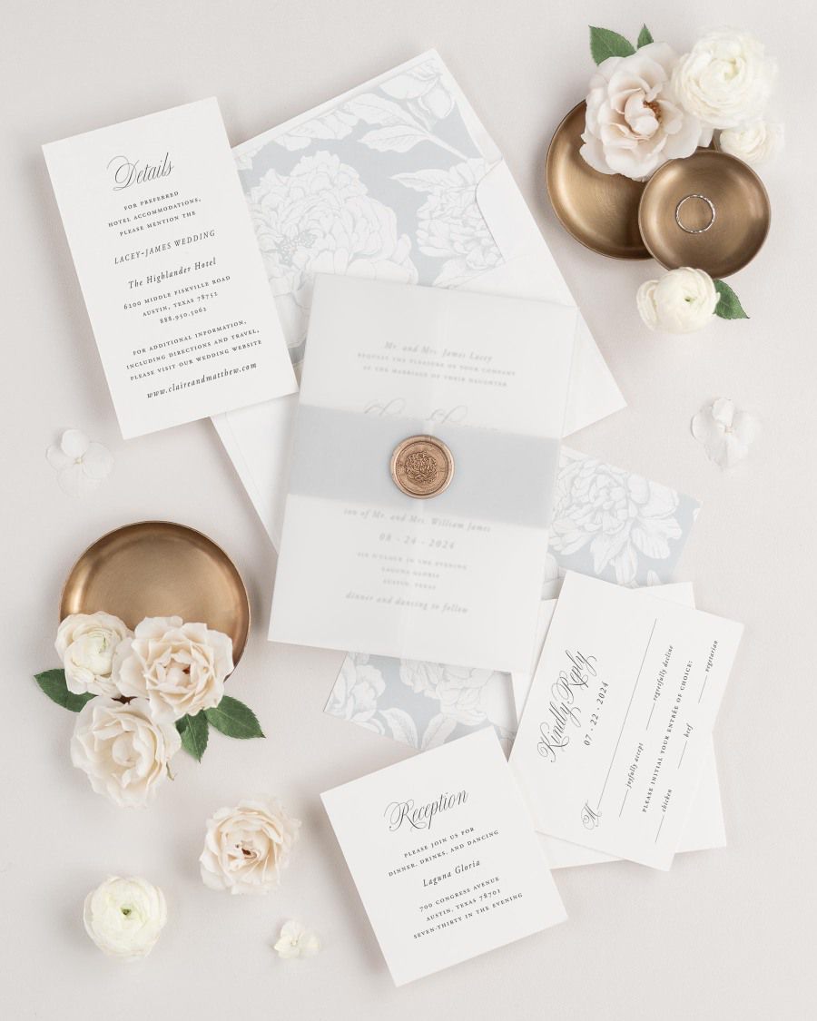 Garden Elegance wedding invitations flat lay with cloud blooms liner, cloud belly band, translucent vellum jacket, and gold florette wax seal.