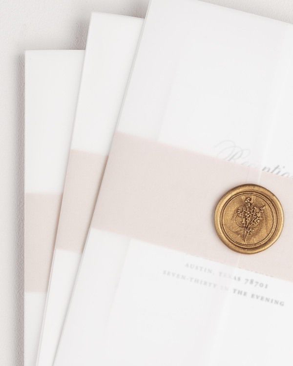 Garden Elegance wedding invitation with a rose gold belly band, translucent vellum jacket, and gold posy wax seal.