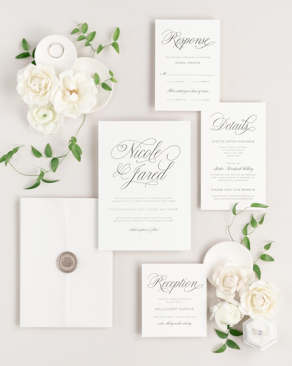 Garden Script wedding invitations flat lay with translucent vellum jacket, and bronze florette wax seal.