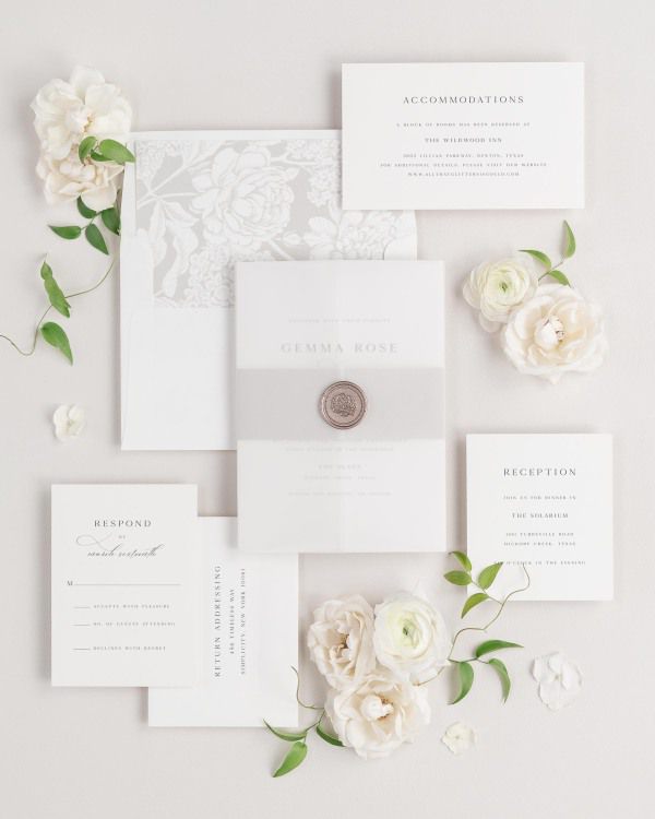 Gemma wedding invitations flat lay with stone hydrangea liner, stone belly band, translucent vellum jacket, and bronze florette wax seal.