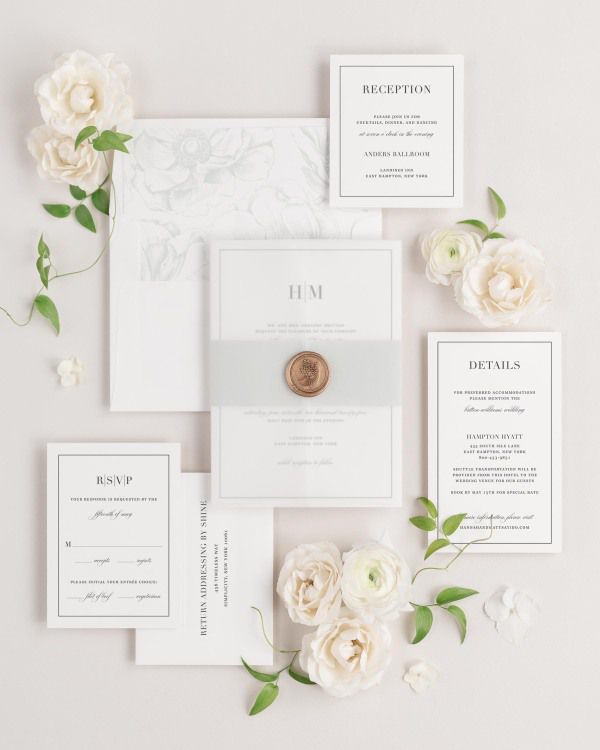 Glam Monogram wedding invitations flat lay with sea salt anemones liner, sea salt belly band, translucent vellum jacket, and gold posy wax seal.