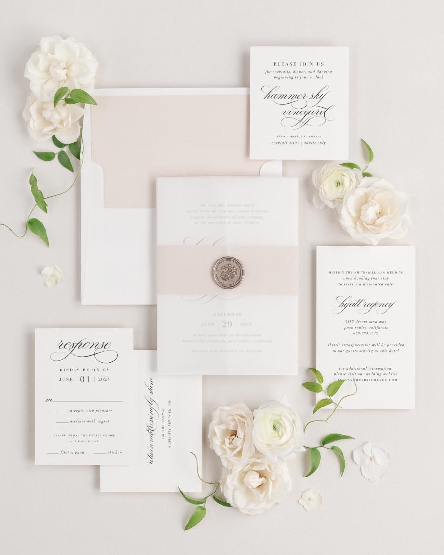 Haley wedding invitations flat lay with rose gold solid liner, rose gold belly band, translucent vellum jacket, and bronze florette wax seal.