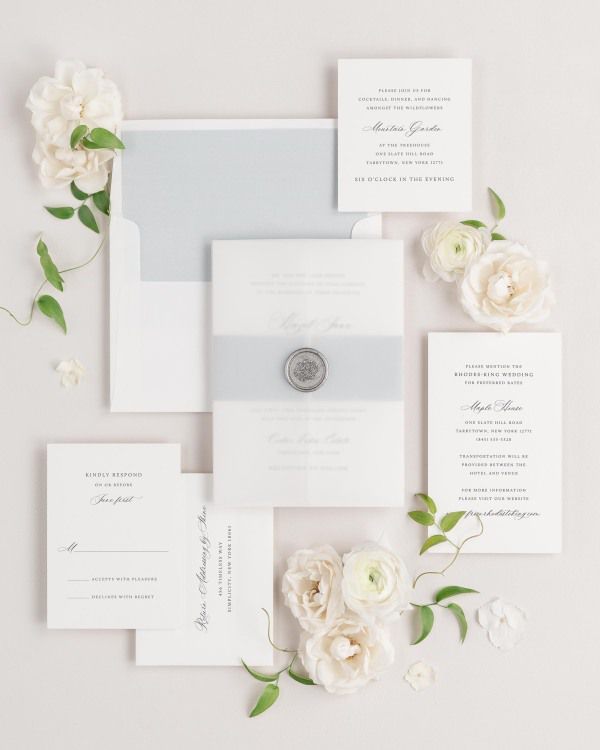 Hazel wedding invitation with a cloud belly band, translucent vellum jacket, and silver florette wax seal.