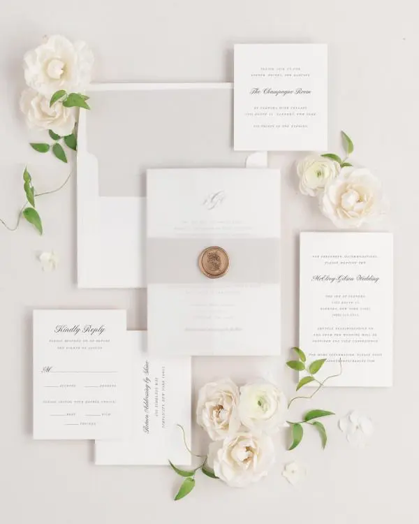 Jennifer wedding invitations flat lay with stone solid liner, stone belly band, translucent vellum jacket, and gold posy wax seal.