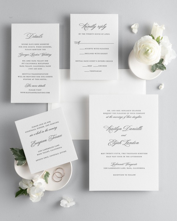 All pieces of the Kaitlyn letterpress wedding invitation suite, including the invitation, small and large enclosures, and response card.