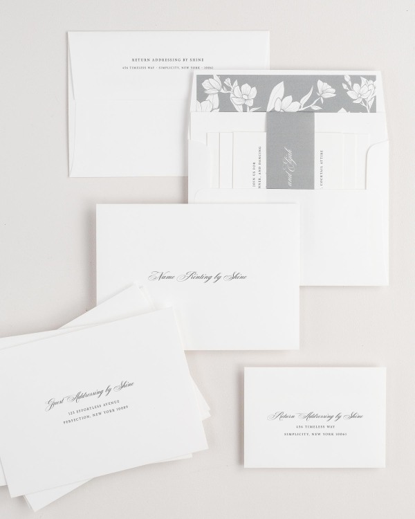 Kaitlyn wedding invitation envelopes with guest addressing, return addressing, and name printing services. Inner envelope features a magnolia liner and slate belly band.