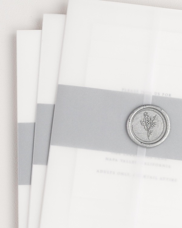 Kaitlyn wedding invitation with a slate belly band, translucent vellum jacket, and silver posy wax seal.