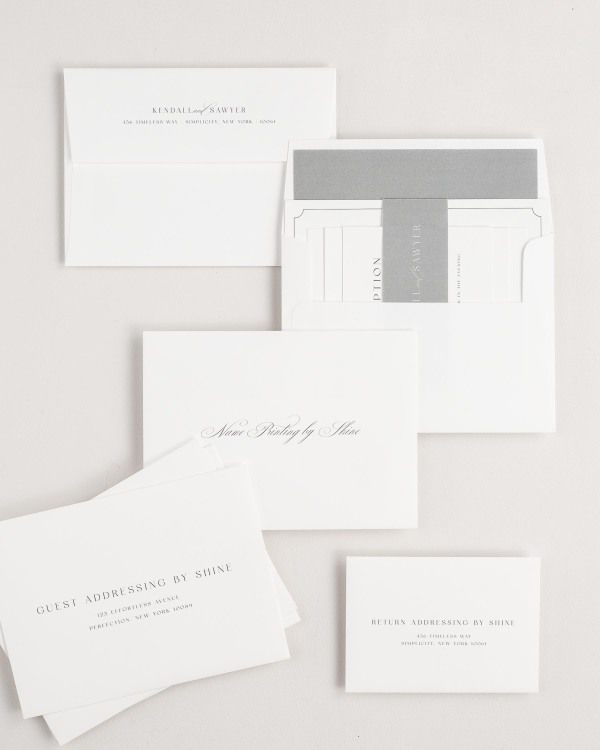 Kendall wedding invitation envelopes with guest addressing, return addressing, and name printing services. Inner envelope features a solid liner and slate belly band.