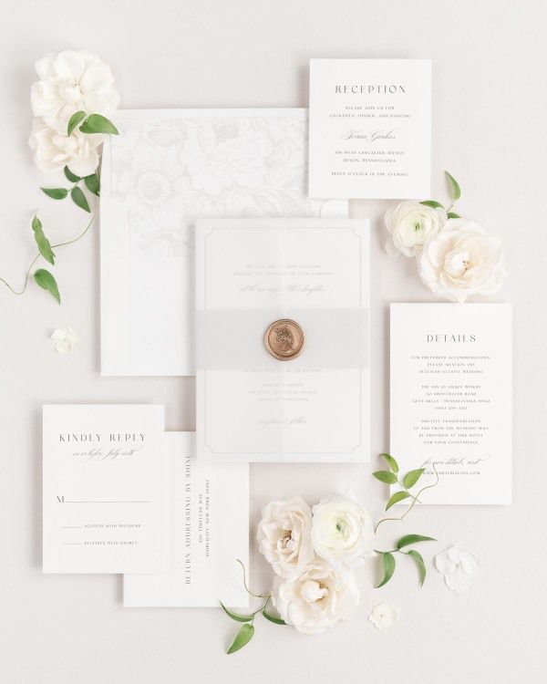 Kendall wedding invitation with a soft gray belly band, translucent vellum jacket, and gold posy wax seal.