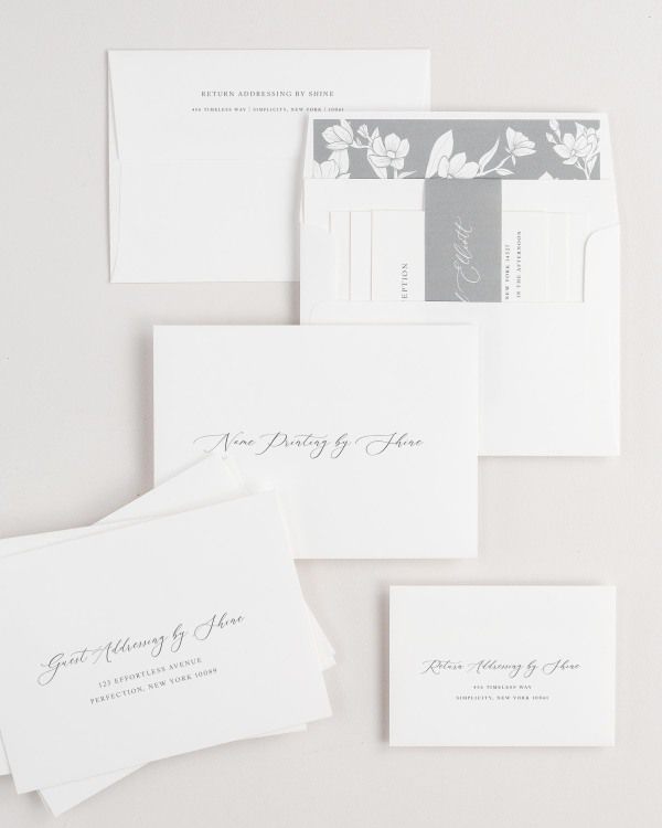 Lily wedding invitation envelopes with guest addressing, return addressing, and name printing services. Inner envelope features a magnolia liner and slate belly band.
