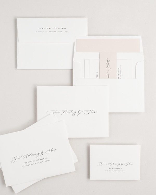 Lily wedding invitation envelopes with guest addressing, return addressing, and name printing services. Inner envelope features a solid liner and rose gold belly band.
