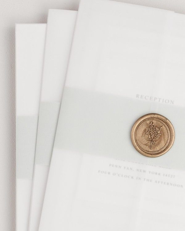 Lily wedding invitation with a sea salt belly band, translucent vellum jacket, and gold posy wax seal.