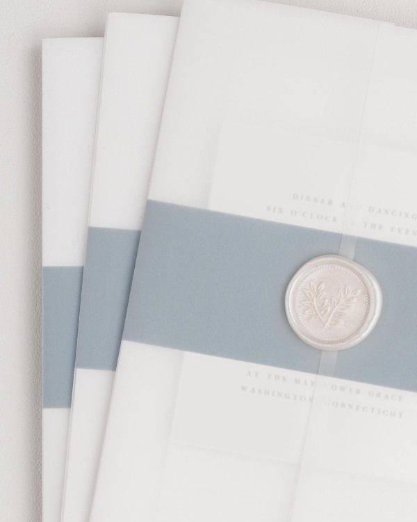 Nadia wedding invitation with a mineral belly band, translucent vellum jacket, and pearl wreath wax seal.