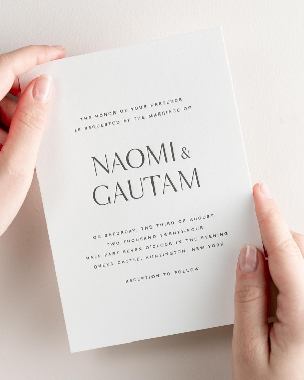 Bride holding her 5x7” Naomi letterpress wedding invitation.
