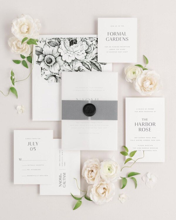 Naomi wedding invitations flat lay with black garden rose liner, black belly band, translucent vellum jacket.