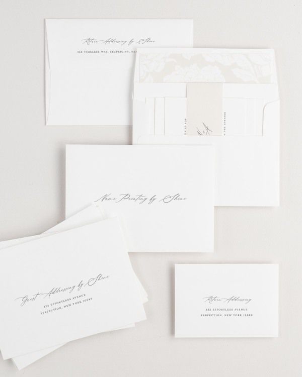 Noelle wedding invitation envelopes with guest addressing, return addressing, and name printing services. Inner envelope features a blooms liner and nude belly band.