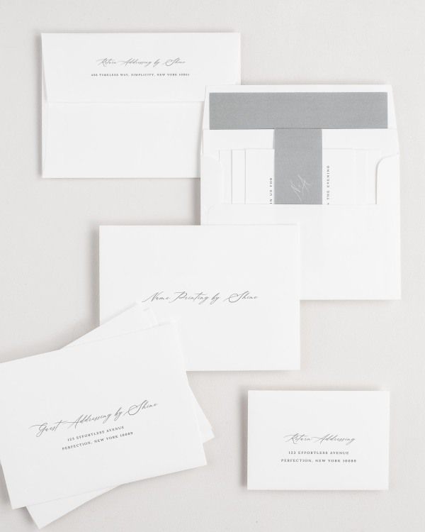 Noelle wedding invitation envelopes with guest addressing, return addressing, and name printing services. Inner envelope features a liner and slate belly band.