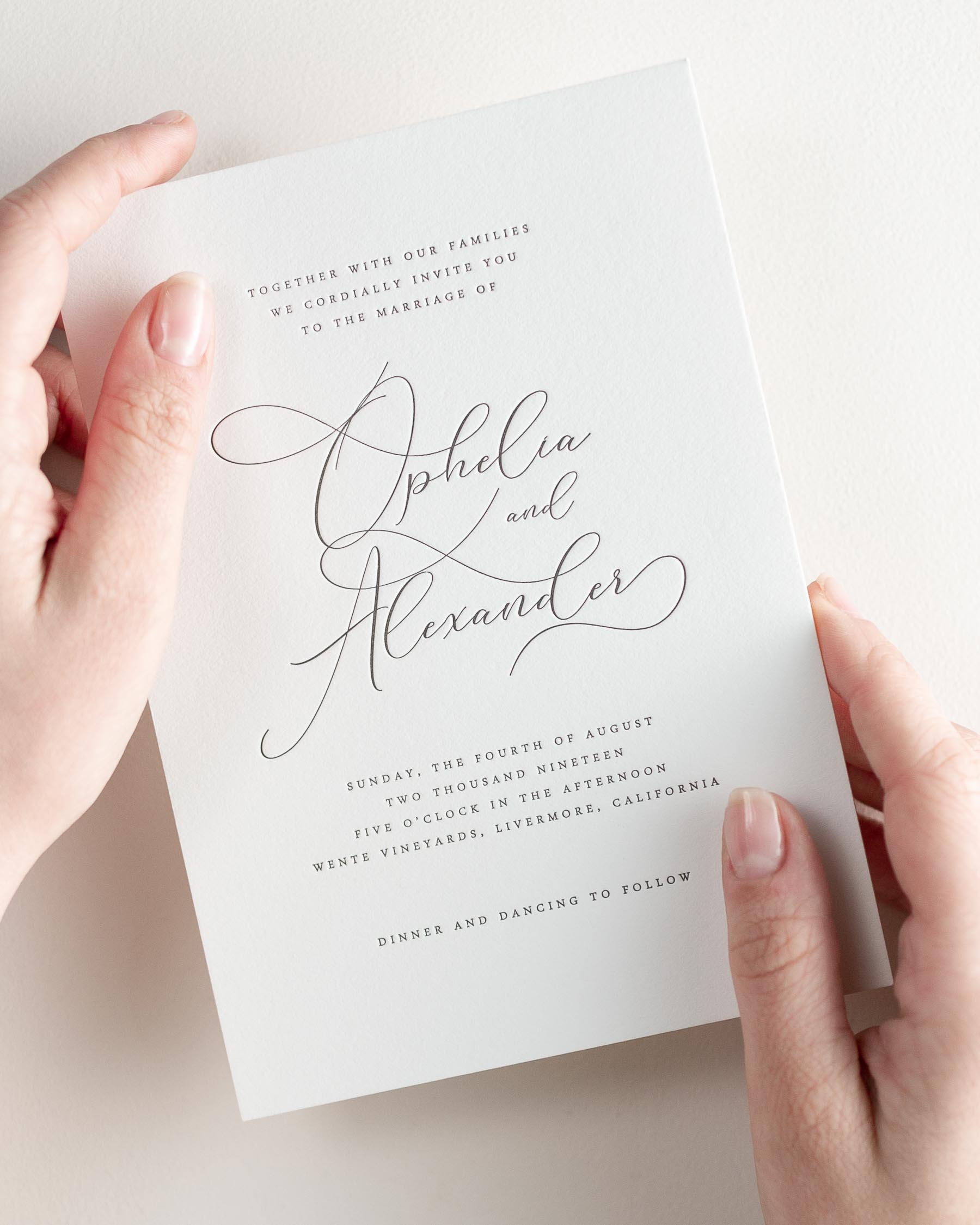Bride holding her 5x7” Ophelia letterpress wedding invitation.