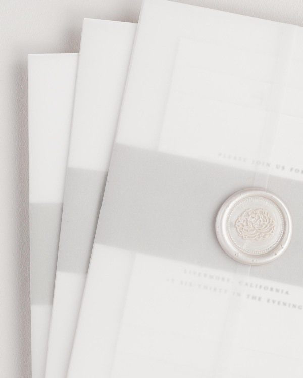 Ophelia wedding invitation with a stone belly band, translucent vellum jacket, and pearl florette wax seal.