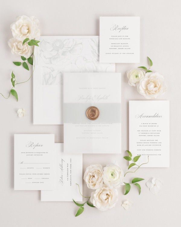 Penelope wedding invitations flat lay with sea salt anemones liner, sea salt belly band, translucent vellum jacket, and gold posy wax seal.