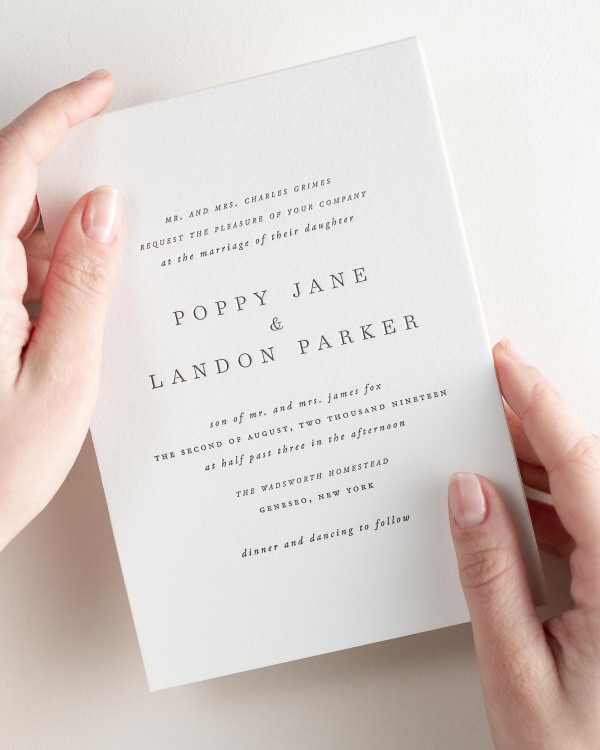 Bride holding her 5x7” Poppy letterpress wedding invitation.