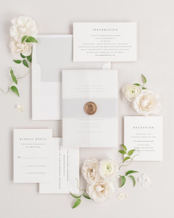 Poppy wedding invitations flat lay with soft gray solid liner, soft gray belly band, translucent vellum jacket, and gold posy wax seal.