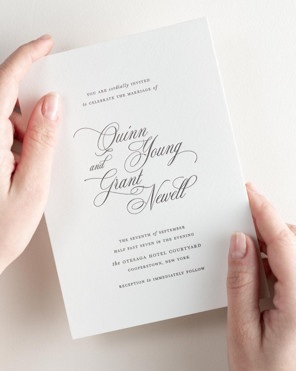 Bride holding her 5x7” Quinn letterpress wedding invitation.