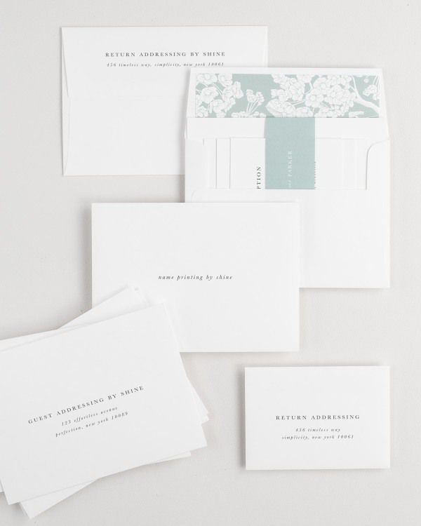 Reagan wedding invitation envelopes with guest addressing, return addressing, and name printing services. Inner envelope features a petite fleur liner and eucalyptus belly band.