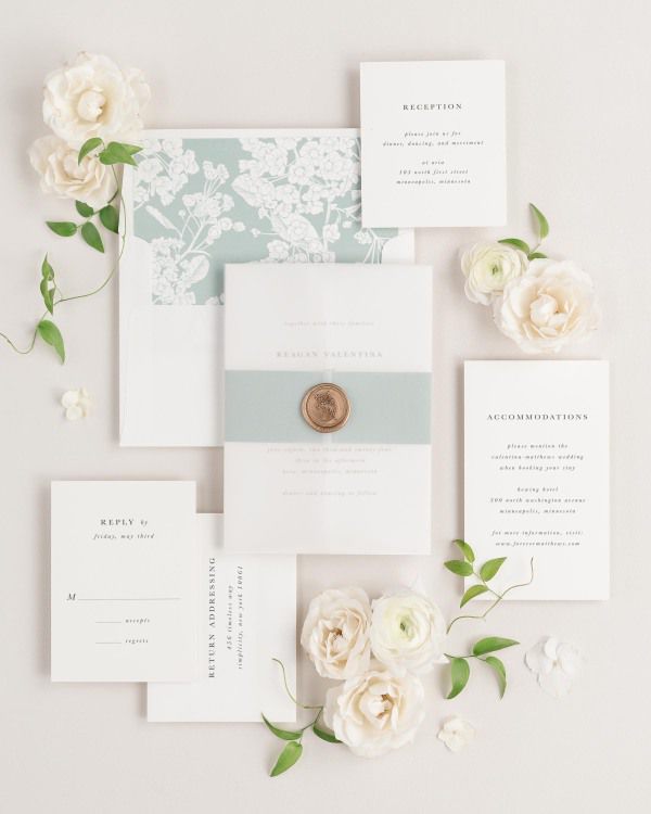 Reagan wedding invitations flat lay with eucalyptus petite fleur liner, eucalyptus belly band, and gold posy wax seal.
