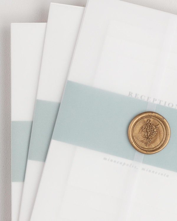 Reagan wedding invitation with a eucalyptus belly band, translucent vellum jacket, and gold posy wax seal.