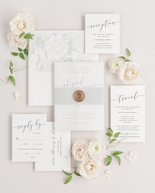 Romantic Calligraphy wedding invitations flat lay with sea salt hydrangea liner, sea salt belly band, translucent vellum jacket, and gold posy wax seal.