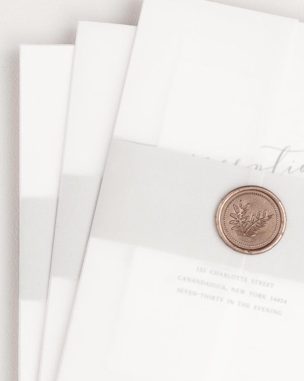 Romantic Calligraphy wedding invitation with a soft gray belly band, translucent vellum jacket, and wreath wax seal.