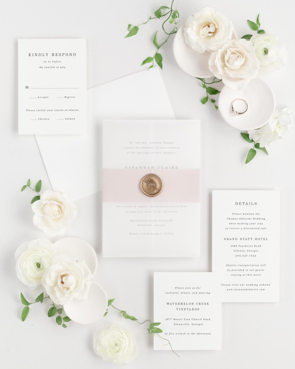 Savannah wedding invitations flat lay with vintage blush belly band, translucent vellum jacket, and gold posy wax seal.