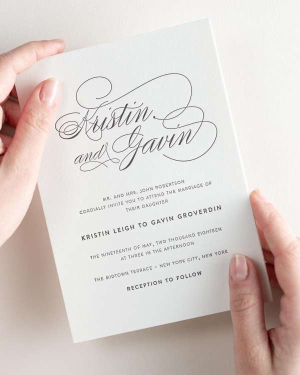 Bride holding her 5x7” Script Elegance letterpress wedding invitation.