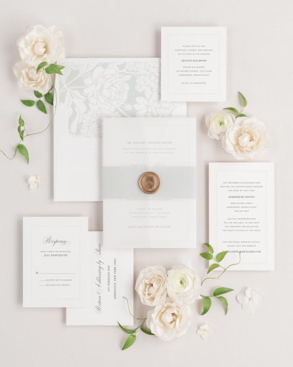 Classic Script wedding invitations flat lay with sea salt belly band, translucent vellum jacket, and gold posy wax seal.